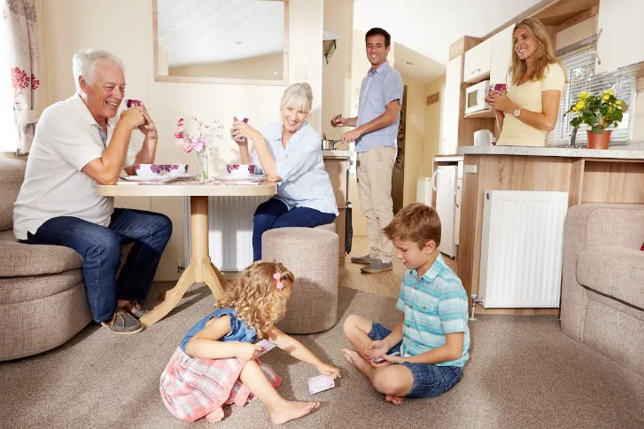 Family relaxing together inside a modern self catering static caravan at Home Farm Holiday Park in Burnham-on-Sea Somerset