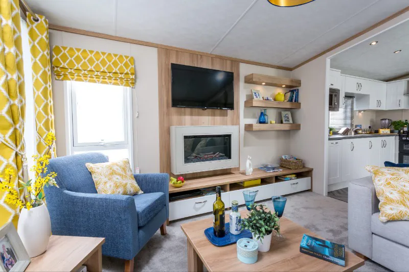Modern lounge interior with sofa and fireplace in platinum holiday caravan at Home Farm Holiday Park Somerset